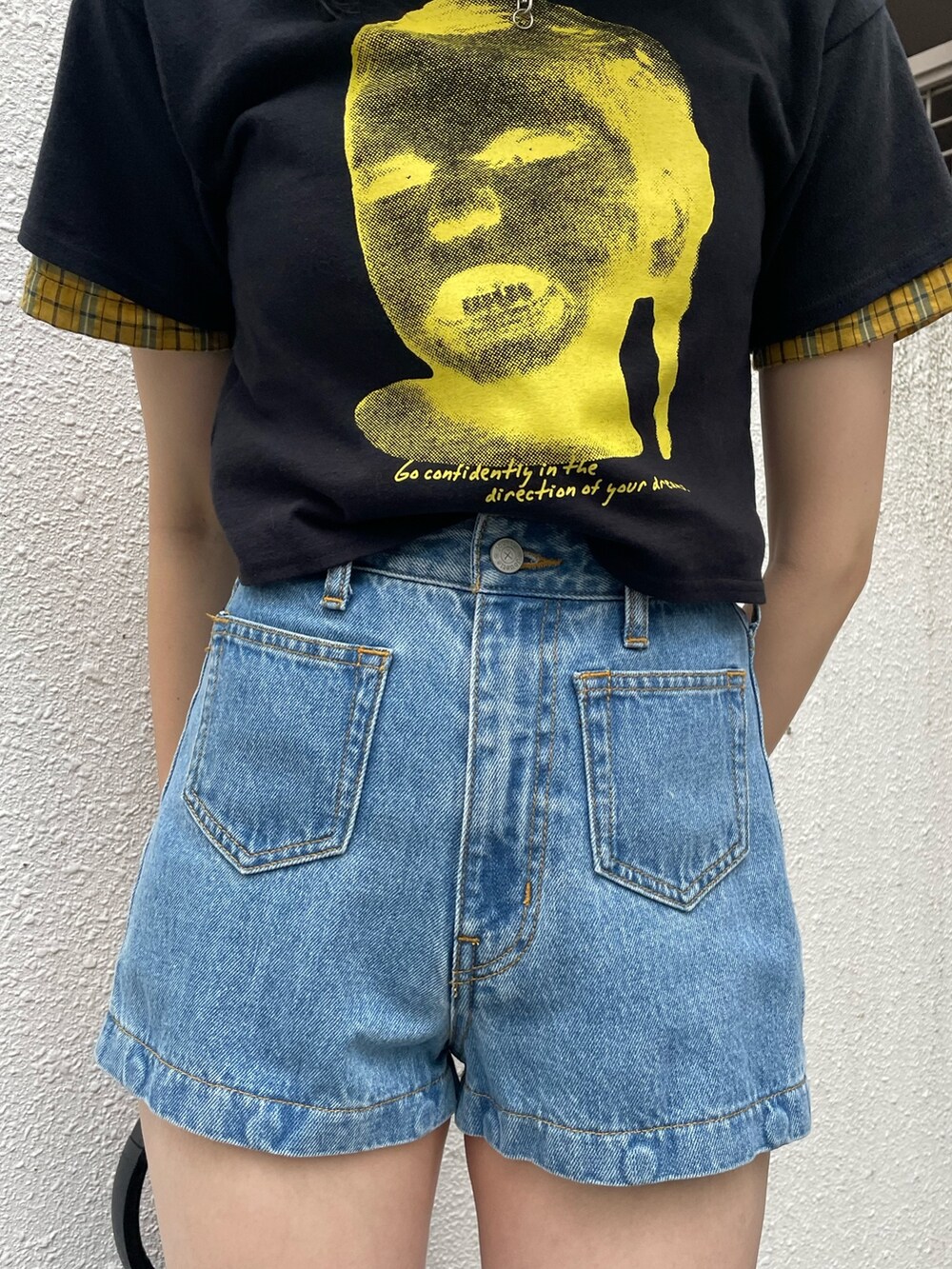 イエロー系のシャツ/ブラウス、ブラック系のTシャツ/カットソー、ブルー系のデニムパンツを着用したレディースの春コーディネートの7枚目の写真