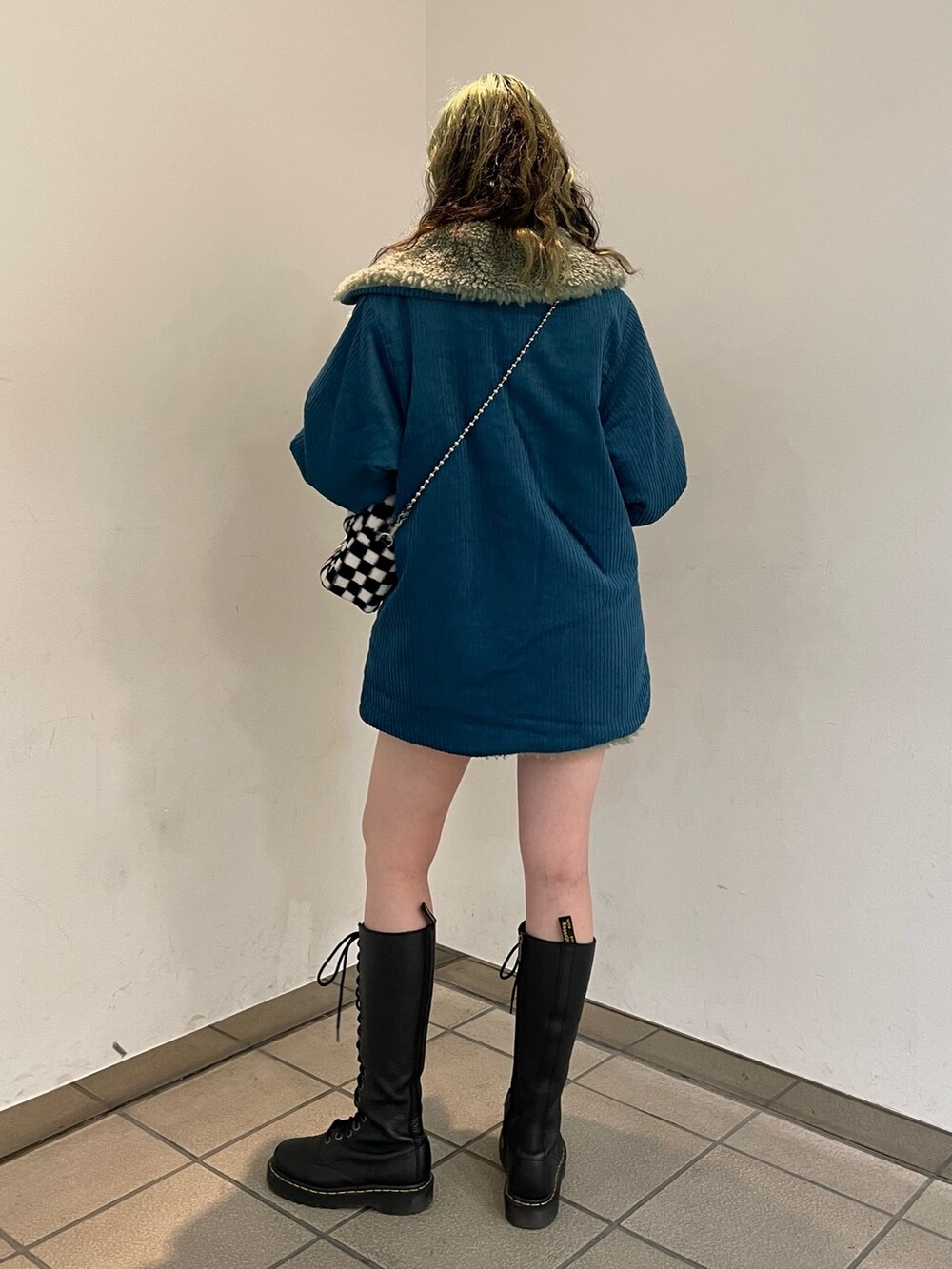 ブラック系のスウェット、ブラック系のボストンバッグ、ブラック系のブーツを着用したレディースの秋コーディネートの3枚目の写真