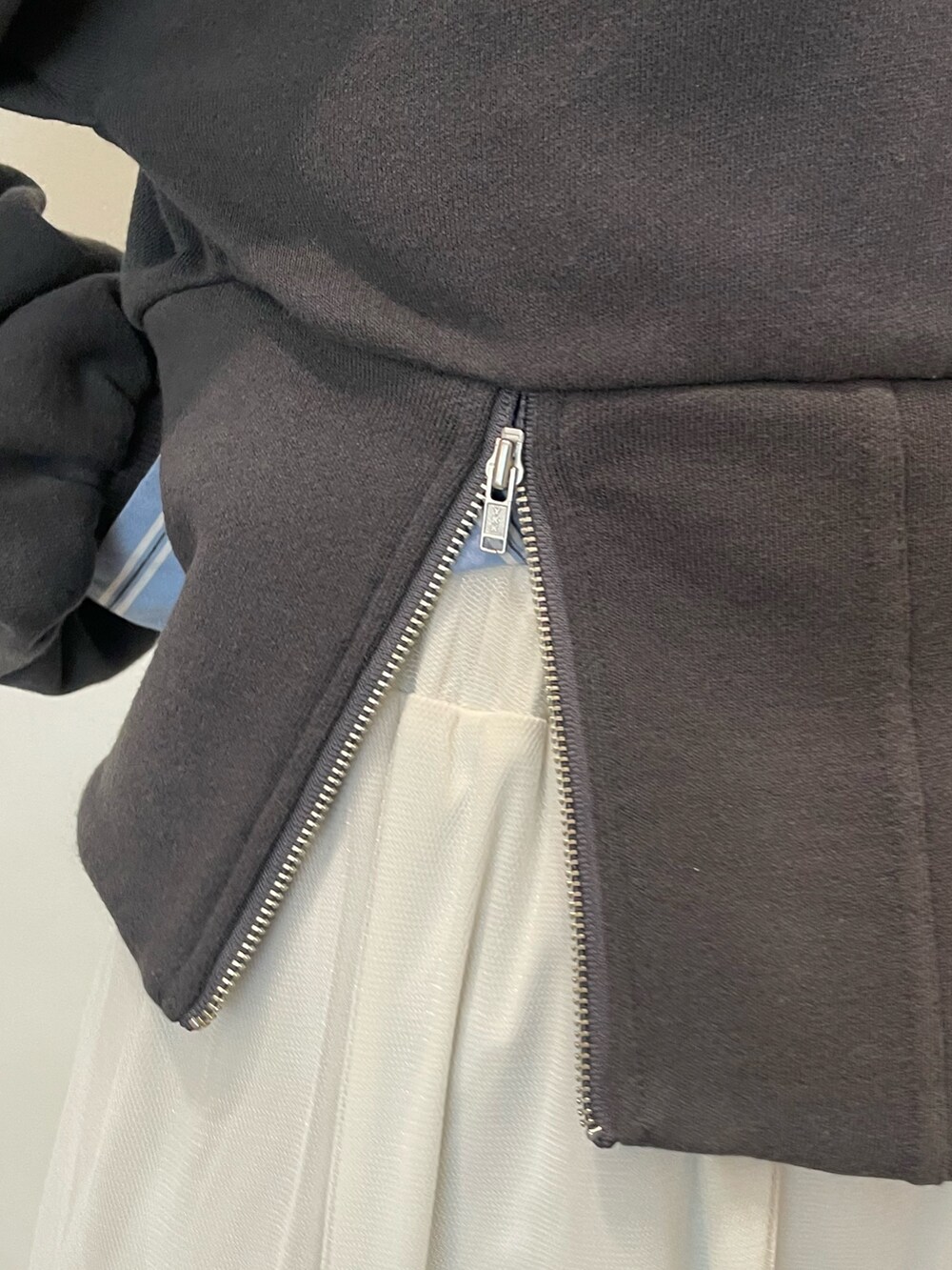 ホワイト系のスカート、ブラック系のスウェット、ブルー系のシャツ/ブラウスを着用したレディースの春コーディネートの6枚目の写真