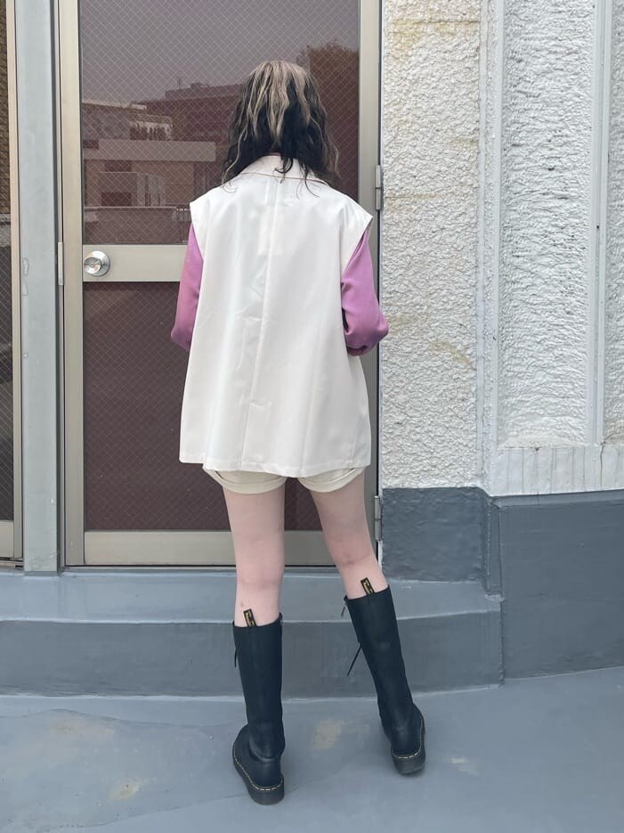 ピンク系のシャツ/ブラウス、ブラック系のブーツ、ホワイト系のベストを着用したレディースの春コーディネートの3枚目の写真
