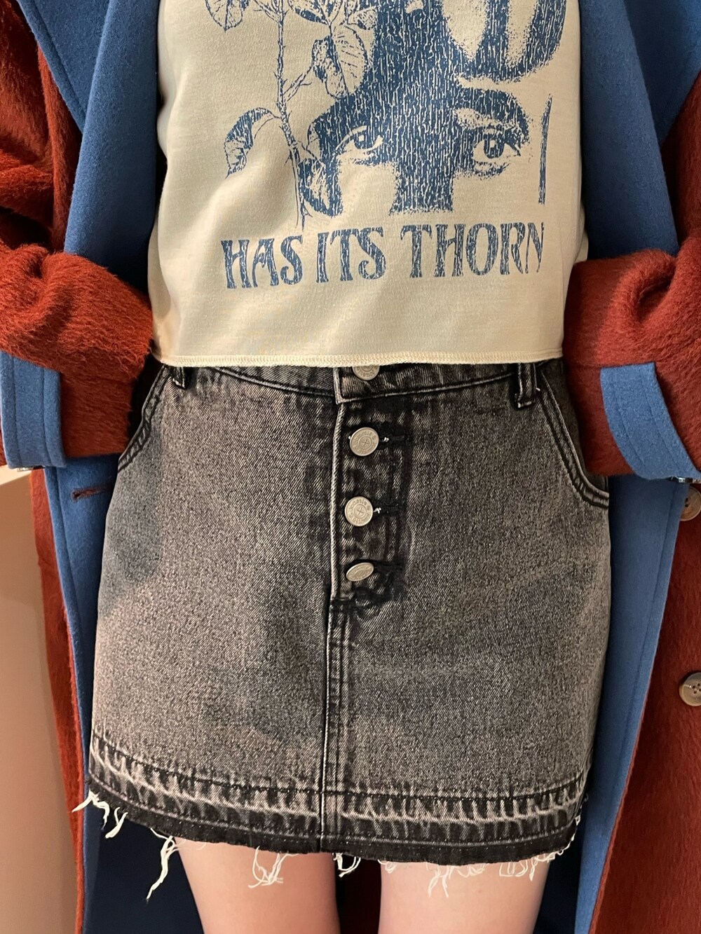 ブラウン系のチェスターコート、ホワイト系のTシャツ/カットソー、ブラック系のデニムパンツを着用したレディースの秋コーディネートの6枚目の写真