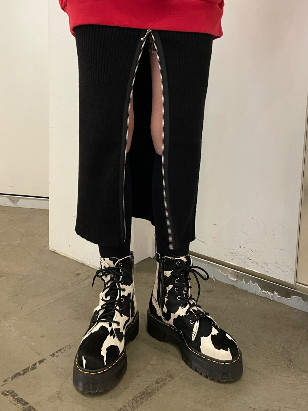 ブラック系のスカート、ブラック系のブーツ、レッド系のTシャツ/カットソーを着用したレディースの秋コーディネートの7枚目の写真