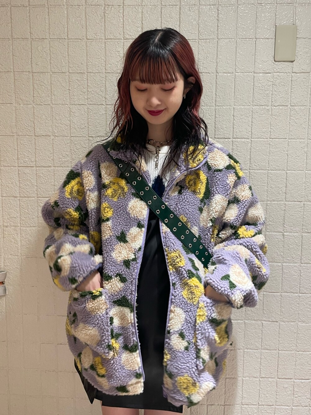 パープル系のブルゾン、ホワイト系のニット/セーター、ブラック系のジャンパースカートを着用したレディースの秋コーディネートの6枚目の写真