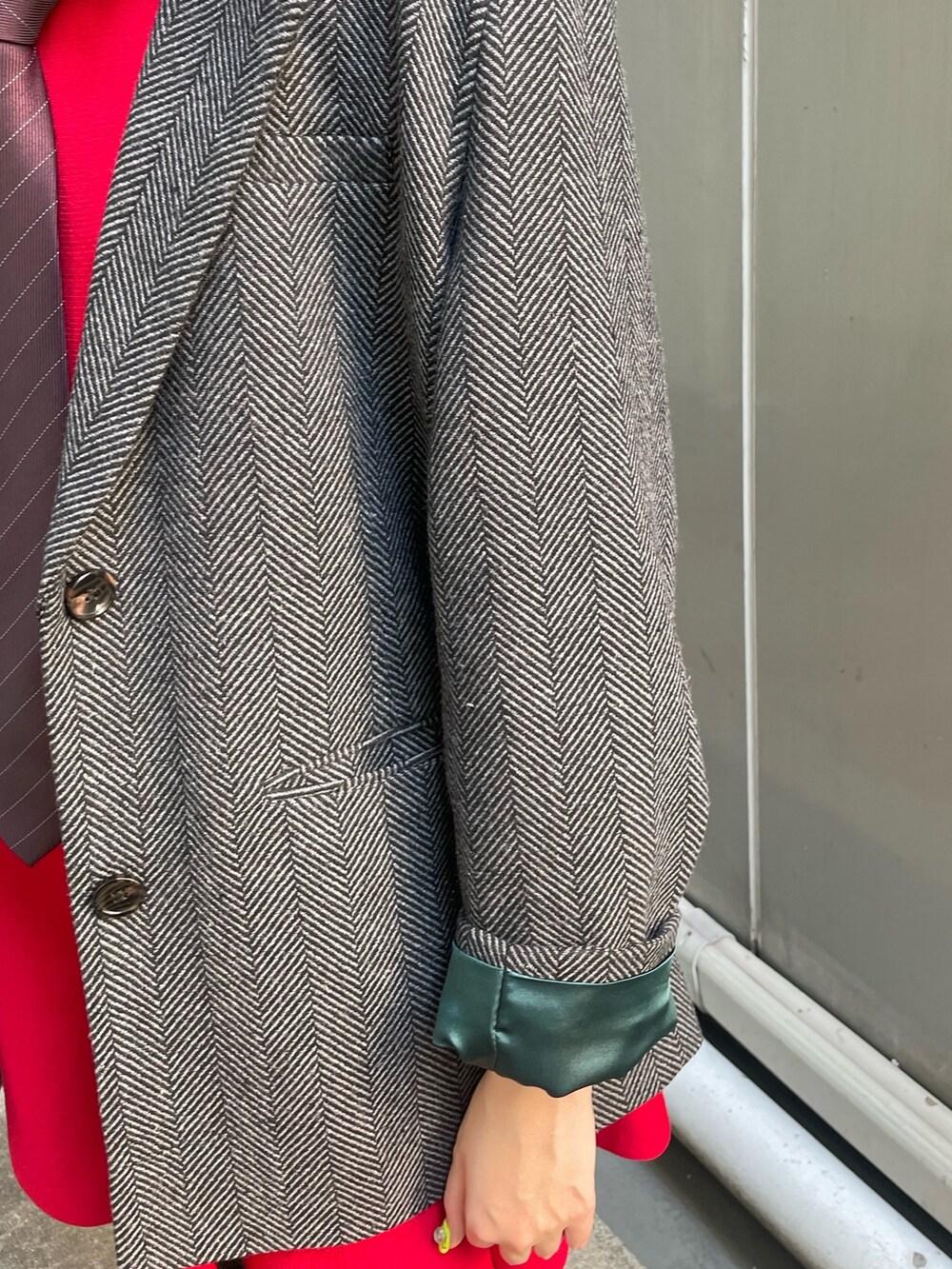 グレー系のテーラードジャケット、レッド系のネクタイ、レッド系のワンピースを着用したレディースの夏コーディネートの7枚目の写真