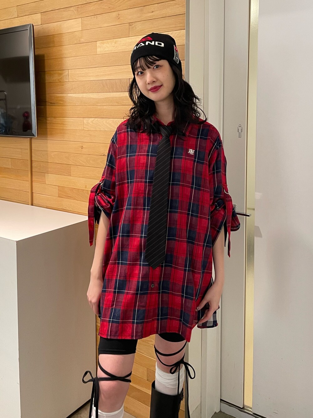 レッド系のシャツ/ブラウス、ブラック系のその他パンツ、ブラック系のブーツを着用したレディースの春コーディネートの6枚目の写真