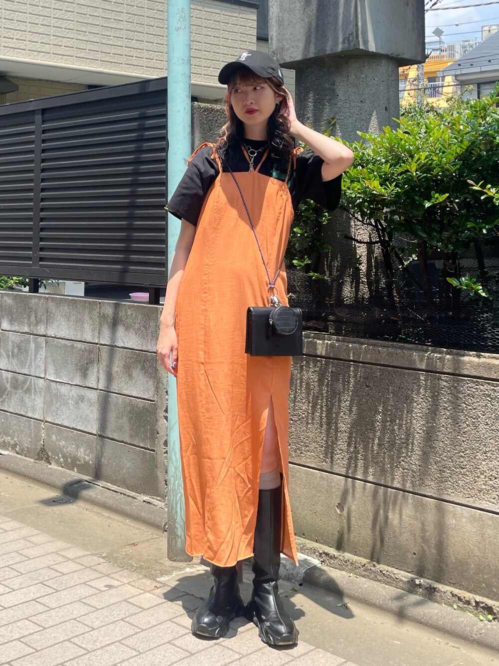 ブラック系のTシャツ/カットソー、オレンジ系のワンピース、ブラック系のショルダーバッグを着用したレディースの夏コーディネートの2枚目の写真