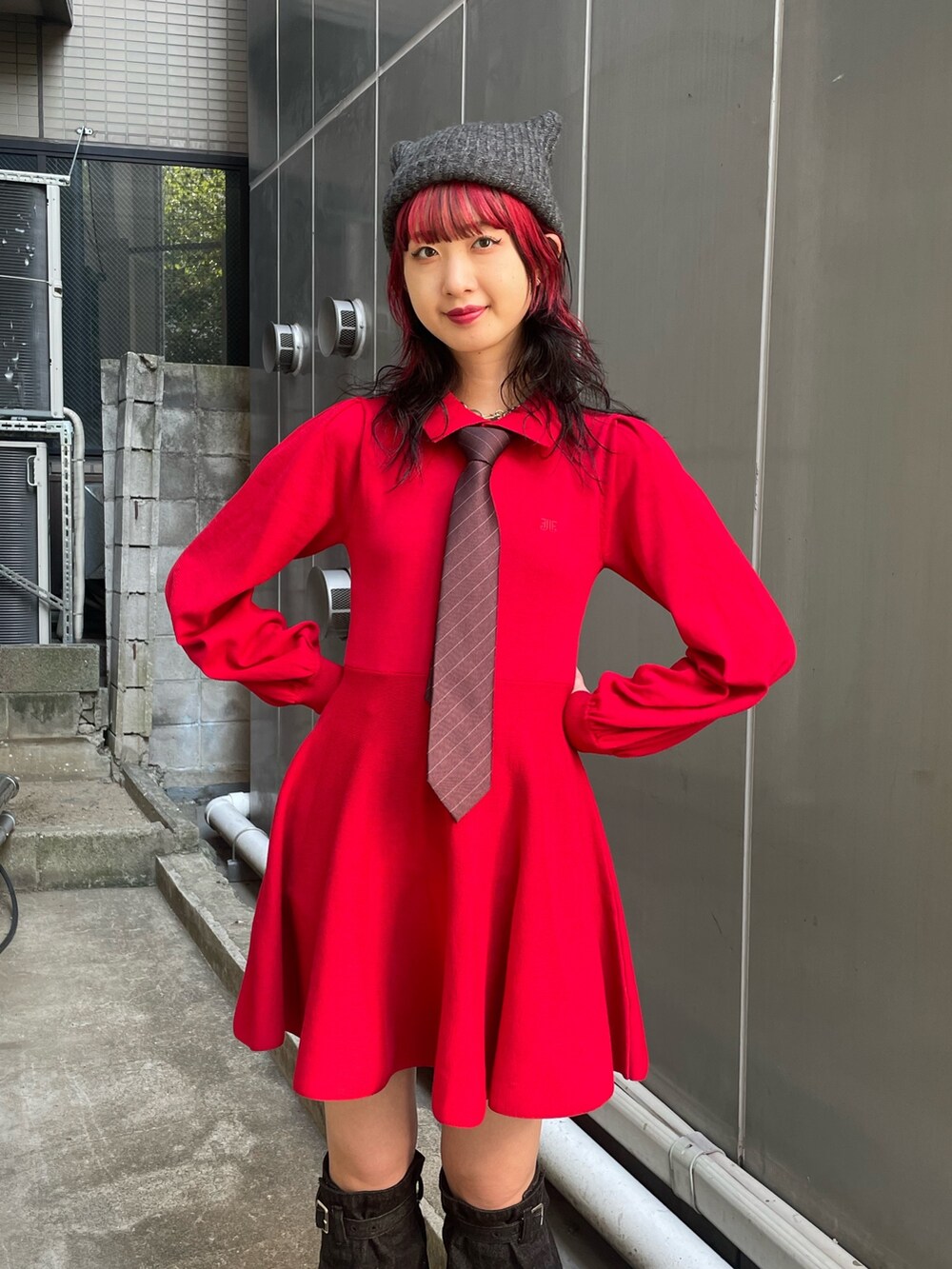 グレー系のテーラードジャケット、レッド系のネクタイ、レッド系のワンピースを着用したレディースの夏コーディネートの5枚目の写真