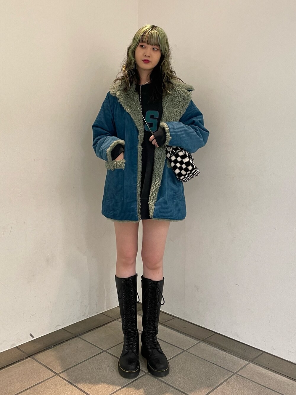 ブラック系のスウェット、ブラック系のボストンバッグ、ブラック系のブーツを着用したレディースの秋コーディネートの2枚目の写真