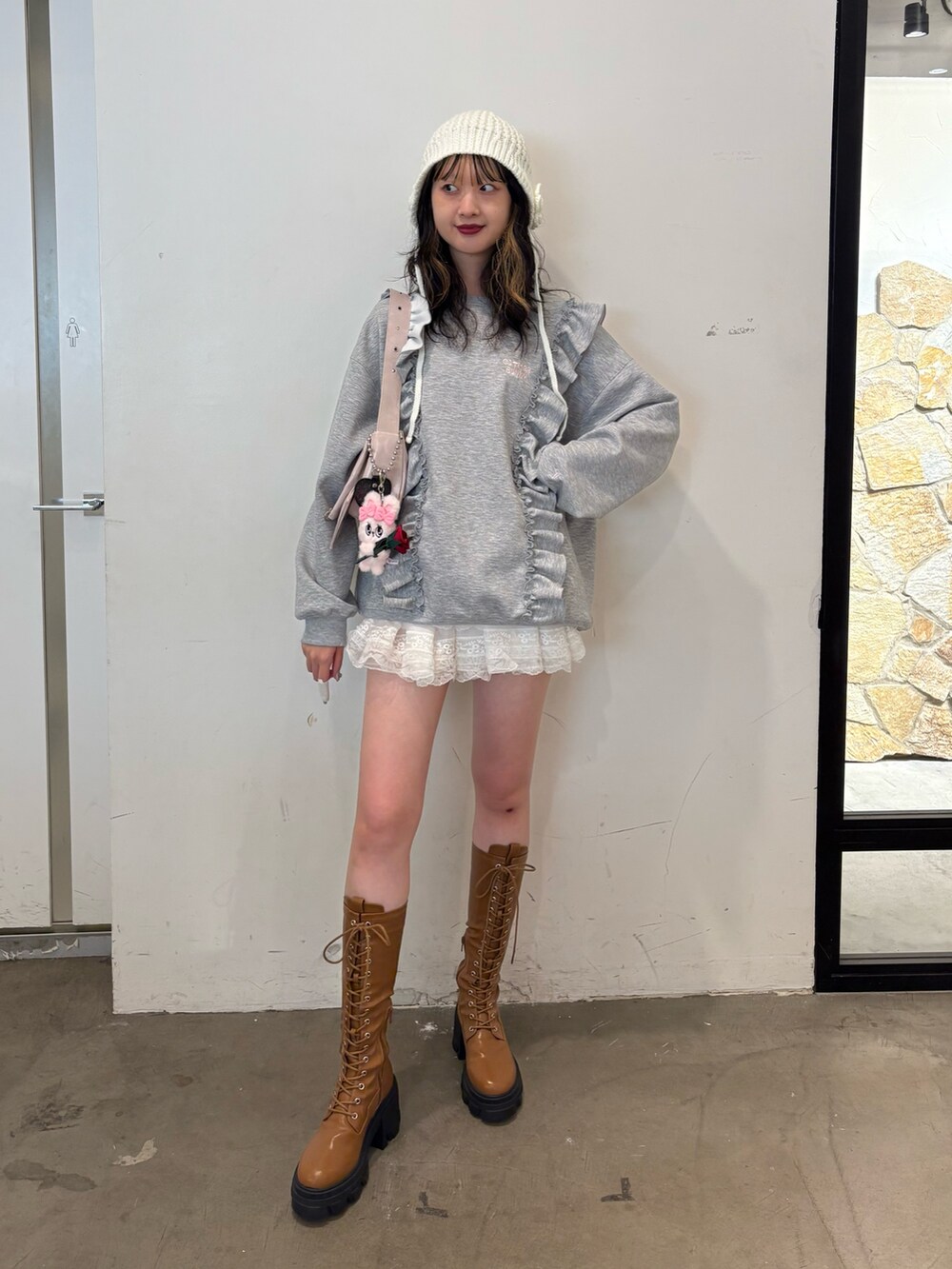 グレー系のスウェット、ピンク系のショルダーバッグ、ブラウン系のブーツを着用したレディースの秋コーディネートの2枚目の写真