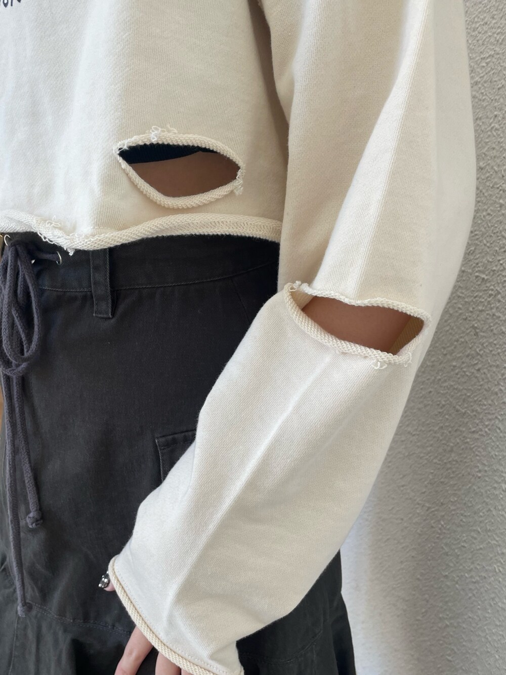 ホワイト系のパーカー、レッド系のブーツ、ブラック系のスカートを着用したレディースの春コーディネートの6枚目の写真