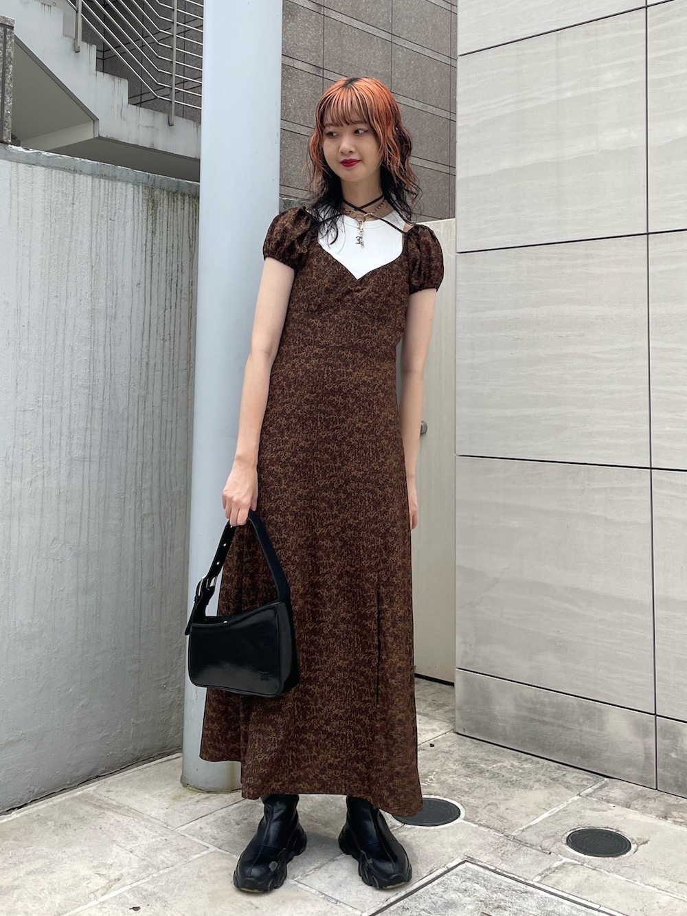 ブラウン系のワンピース、ホワイト系のタンクトップ、ブラック系のハンドバッグを着用したレディースの夏コーディネートの2枚目の写真