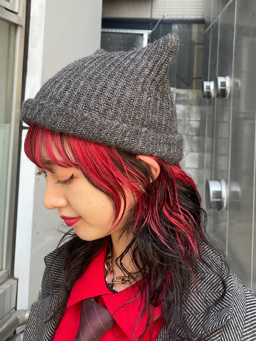 グレー系のテーラードジャケット、レッド系のネクタイ、レッド系のワンピースを着用したレディースの夏コーディネートの9枚目の写真