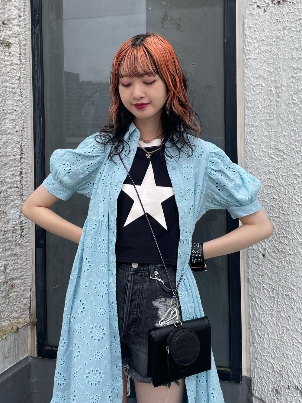 ブルー系のワンピース、ブラック系のショルダーバッグ、ブラック系のデニムパンツを着用したレディースの夏コーディネートの4枚目の写真