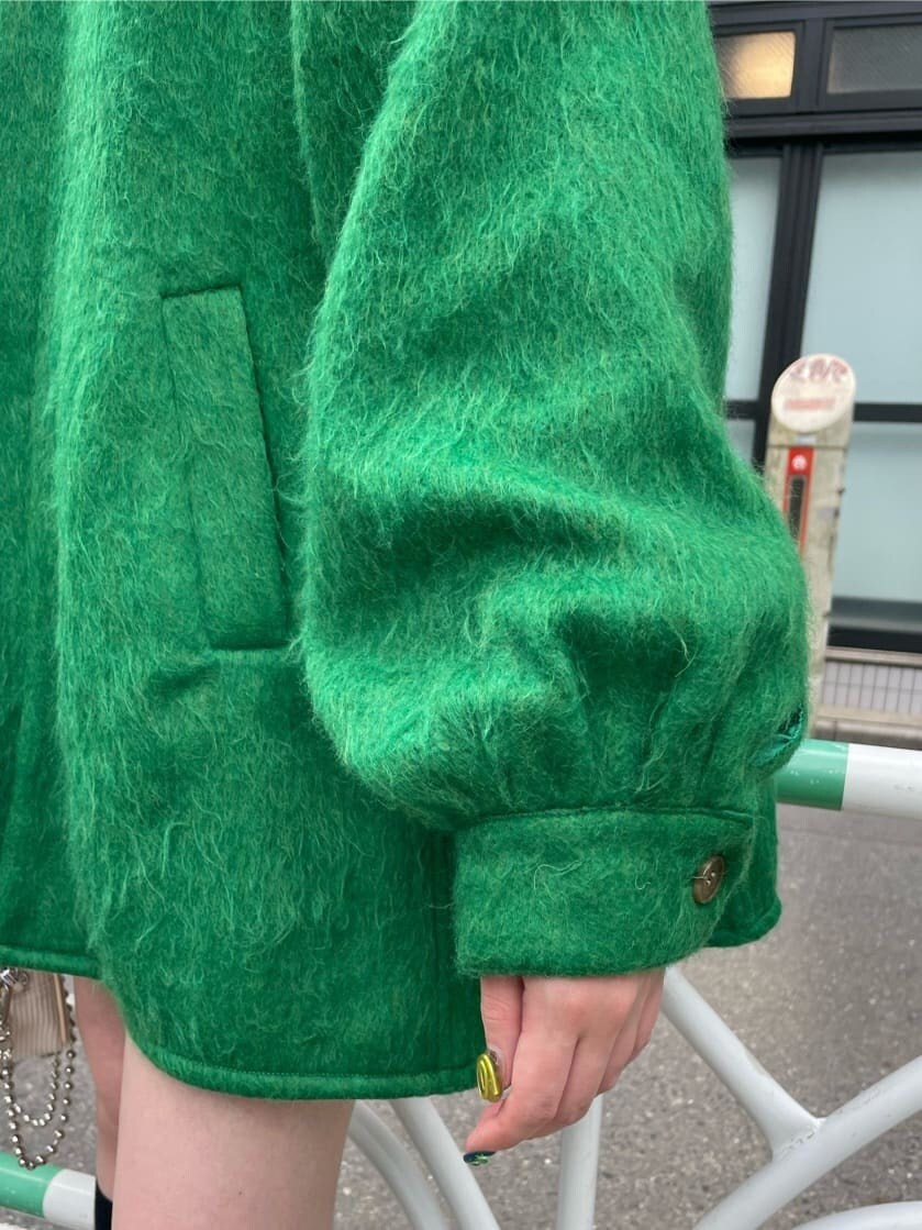 ホワイト系のローファー、グリーン系のその他アウター、ホワイト系のハンドバッグを着用したレディースの秋コーディネートの7枚目の写真