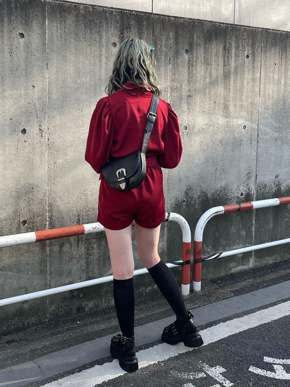 ブラック系のサンダル、レッド系のつなぎ/オールインワン、ブラック系のショルダーバッグを着用したレディースの春コーディネートの3枚目の写真