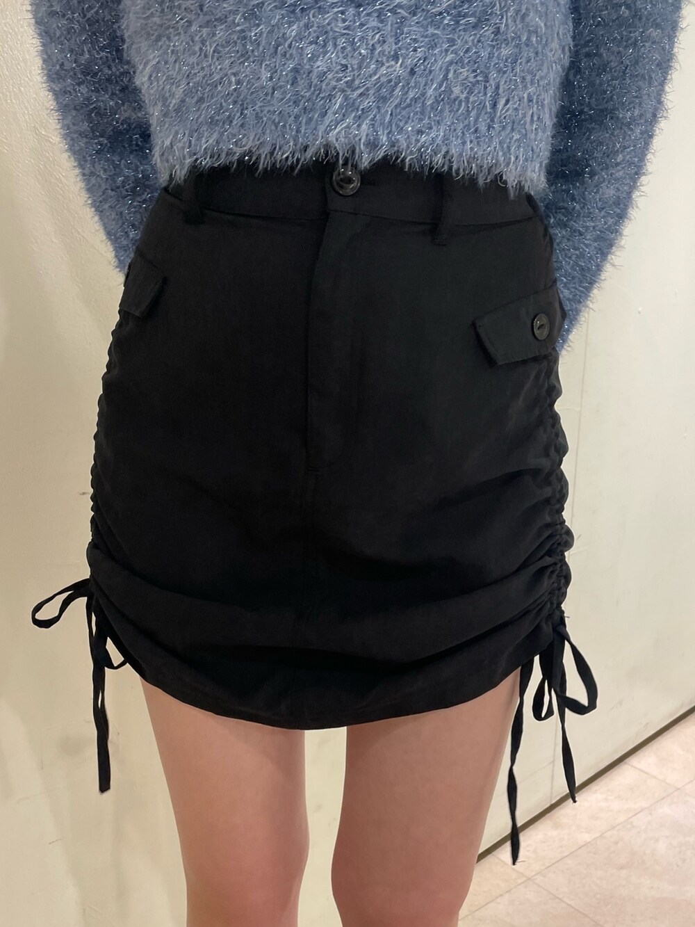 ブルー系のニット/セーター、ホワイト系のタンクトップ、ブラック系のスカートを着用したレディースの冬コーディネートの6枚目の写真