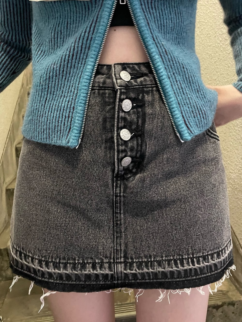 ブルー系のニット/セーター、ブラック系のデニムパンツ、ホワイト系のトートバッグを着用したレディースの秋コーディネートの6枚目の写真