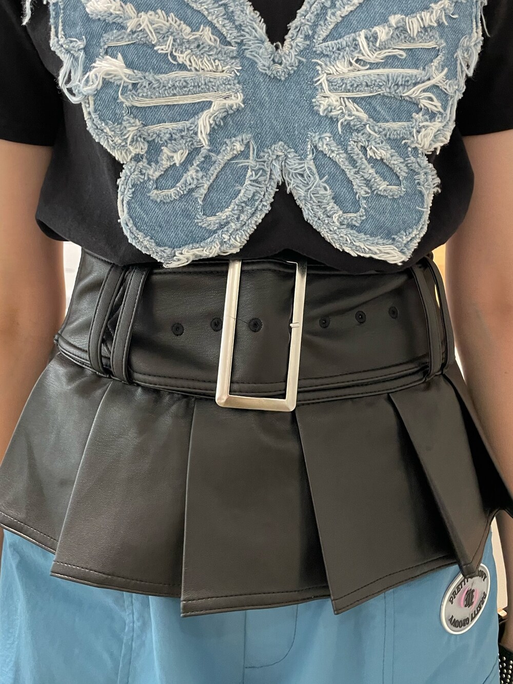 ブラック系のTシャツ/カットソー、ブルー系のカーゴパンツ、ブラック系のその他シューズを着用したレディースの春コーディネートの6枚目の写真
