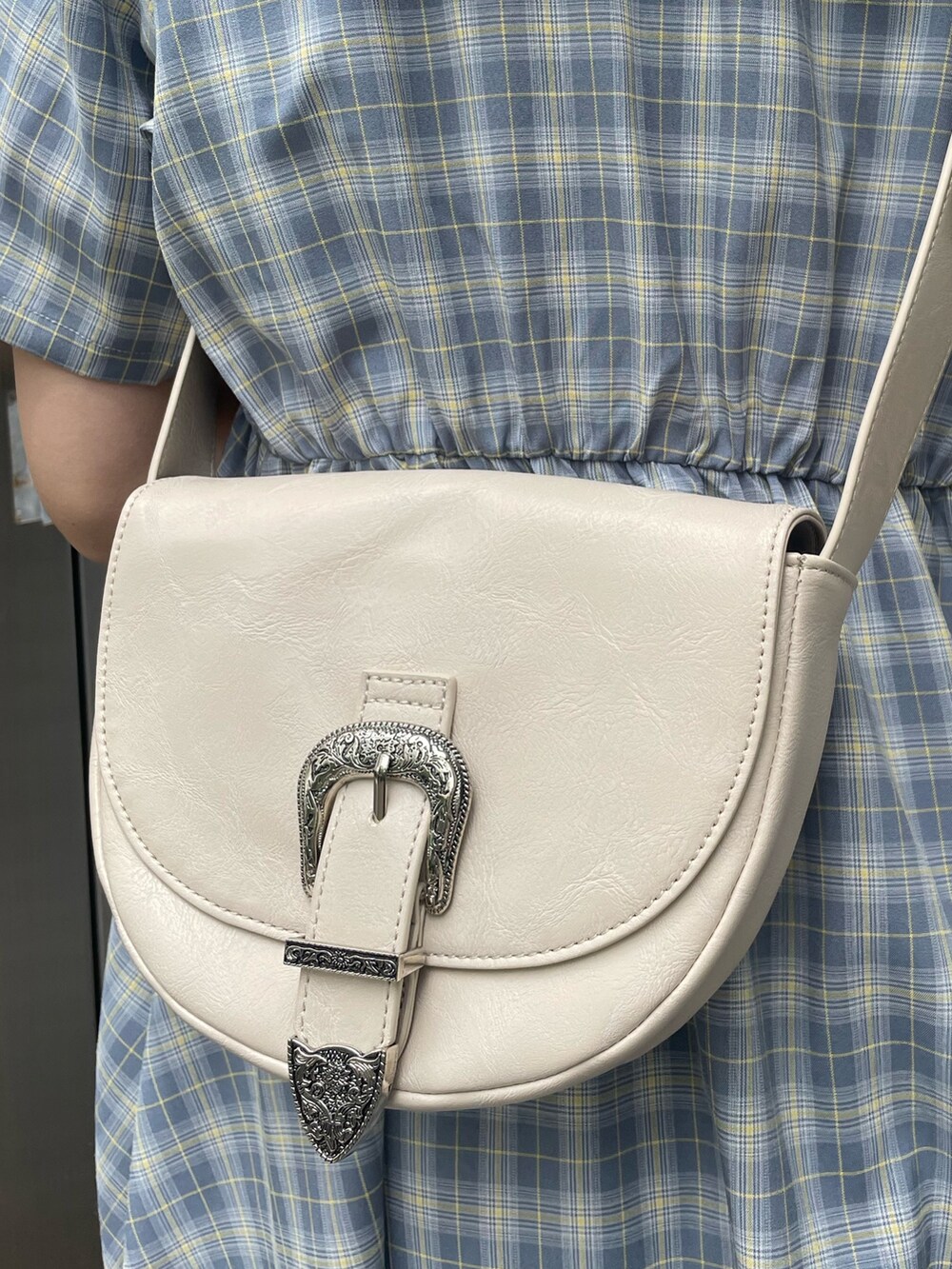 ブルー系のワンピース、ブラック系のデニムパンツ、ホワイト系のショルダーバッグを着用したレディースの春コーディネートの9枚目の写真