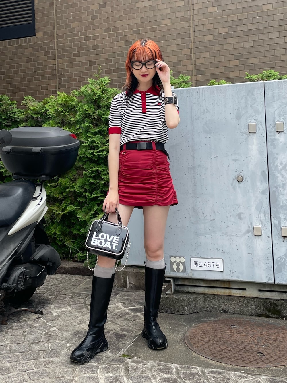 ホワイト系のニット/セーター、ブラック系のボストンバッグ、レッド系のスカートを着用したレディースの夏コーディネートの2枚目の写真