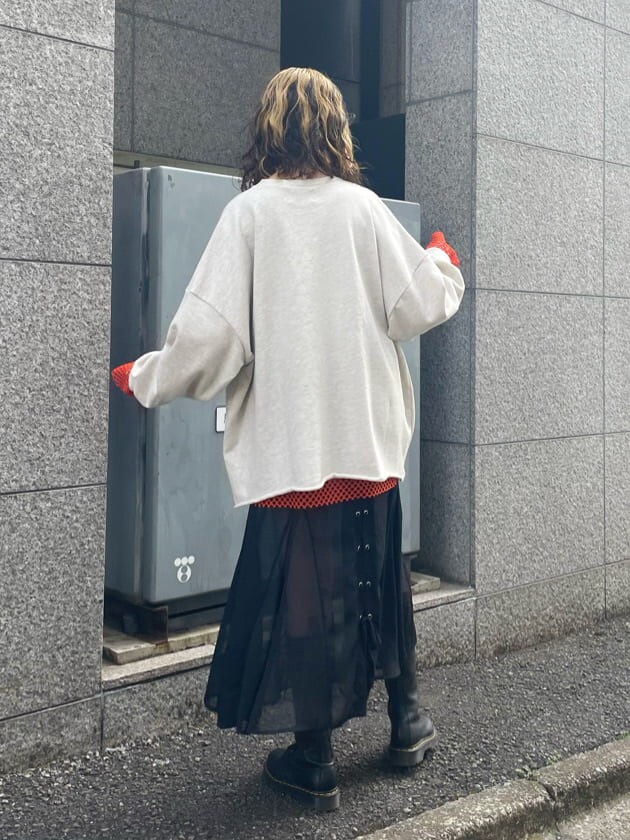 ブラック系のブーツ、ブラック系のスカート、オレンジ系のTシャツ/カットソーを着用したレディースの春コーディネートの3枚目の写真