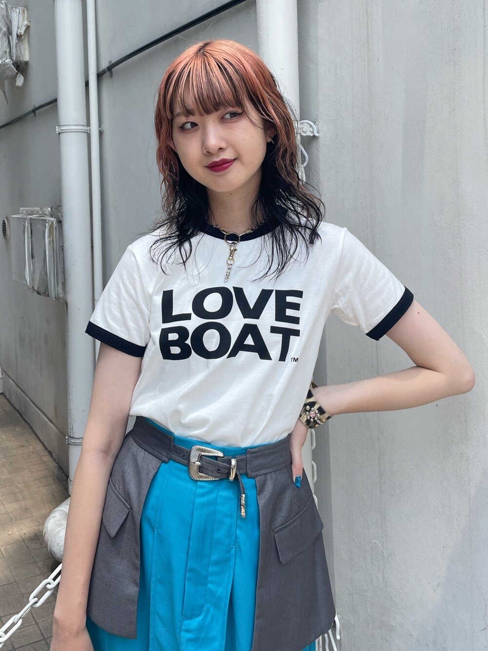 ホワイト系のTシャツ/カットソー、ブルー系のスカート、ブラック系のハンドバッグを着用したレディースの春コーディネートの3枚目の写真