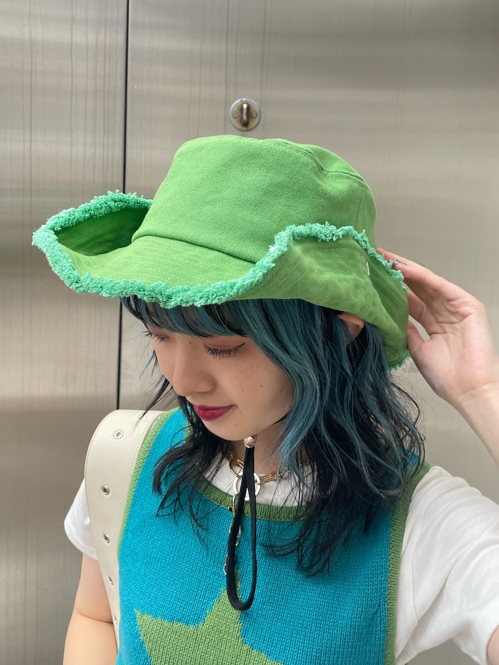 ブラック系のデニムパンツ、ブルー系のタンクトップ、ホワイト系のTシャツ/カットソーを着用したレディースの春コーディネートの7枚目の写真