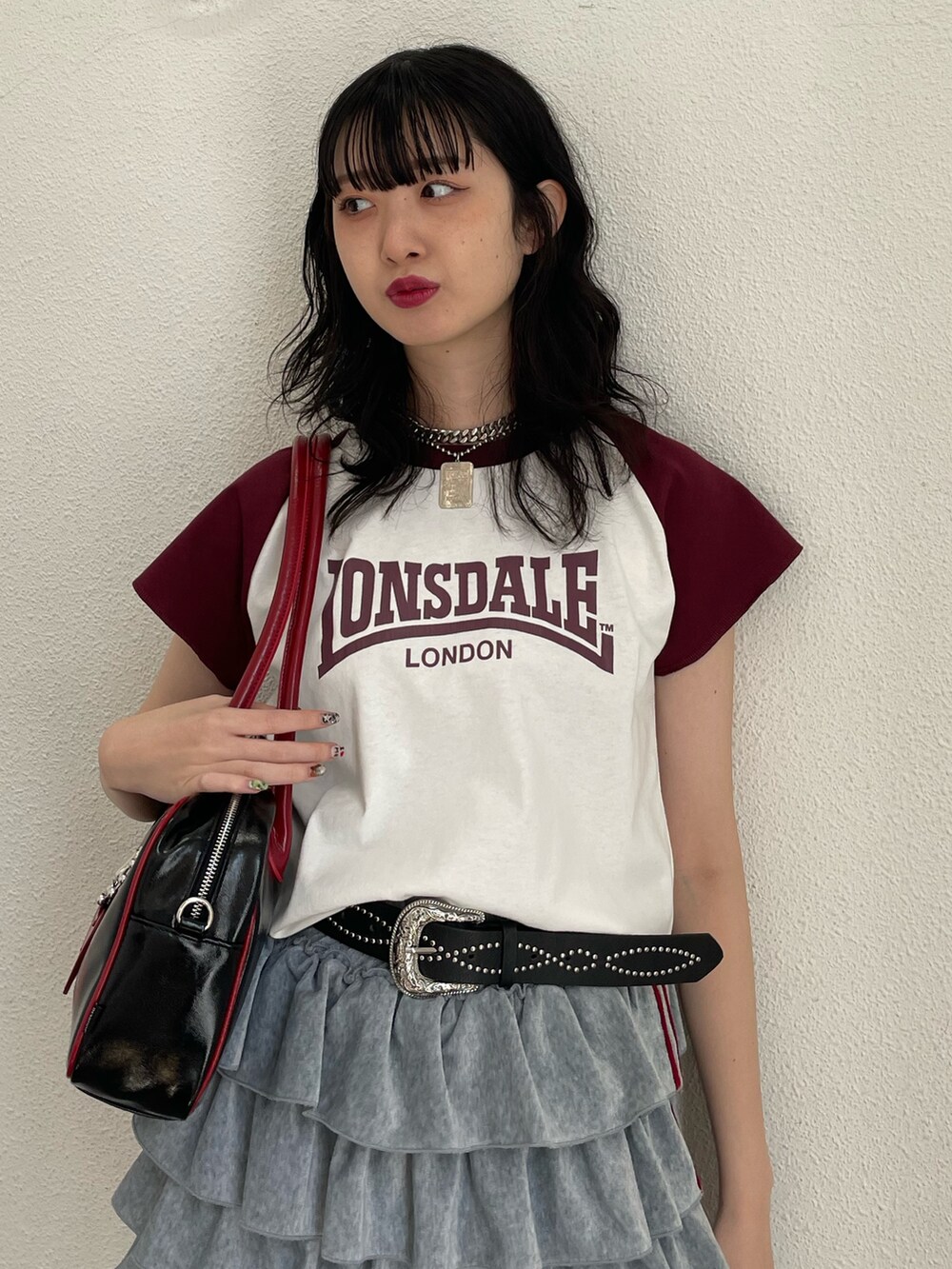 ホワイト系のTシャツ/カットソー、グレー系のスカート、ブラック系のボストンバッグを着用したレディースの春コーディネートの3枚目の写真