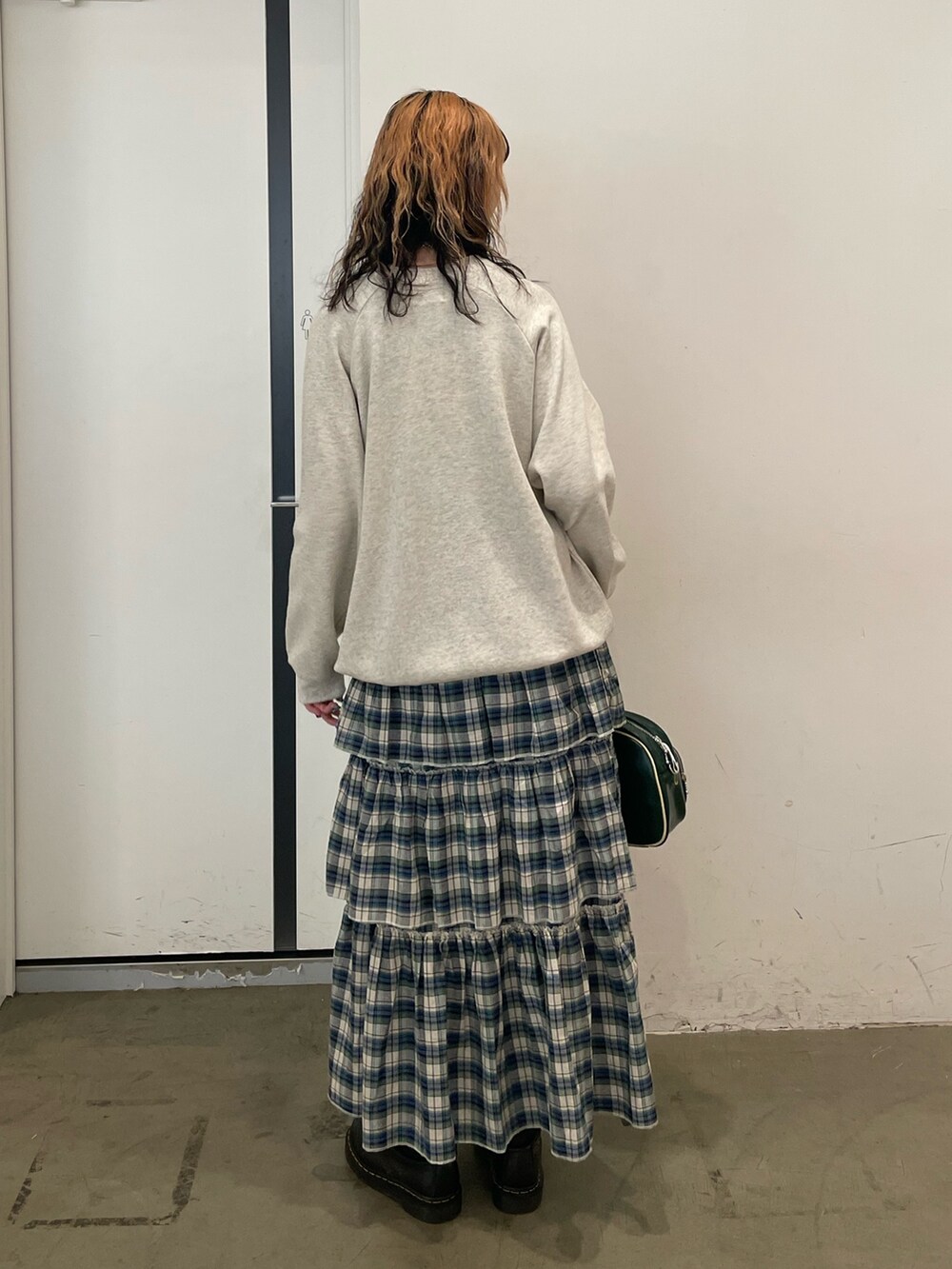 グレー系のスウェット、グリーン系のスカート、グリーン系のボストンバッグを着用したレディースの夏コーディネートの3枚目の写真