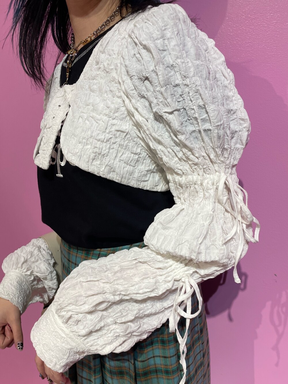 ブラック系のTシャツ/カットソー、ホワイト系のカーディガン/ボレロ、グリーン系のスカートを着用したレディースの冬コーディネートの7枚目の写真