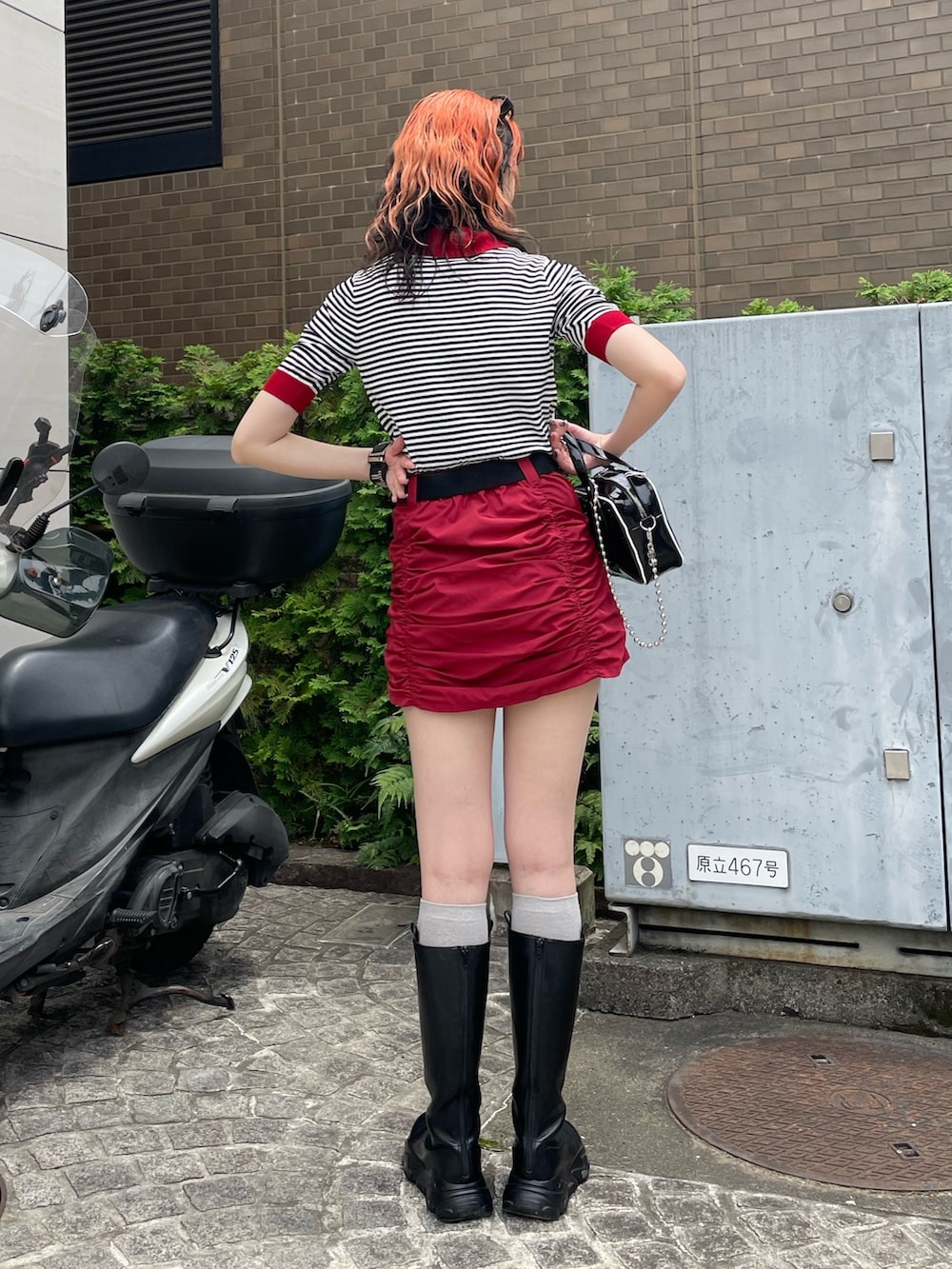 ホワイト系のニット/セーター、ブラック系のボストンバッグ、レッド系のスカートを着用したレディースの夏コーディネートの3枚目の写真