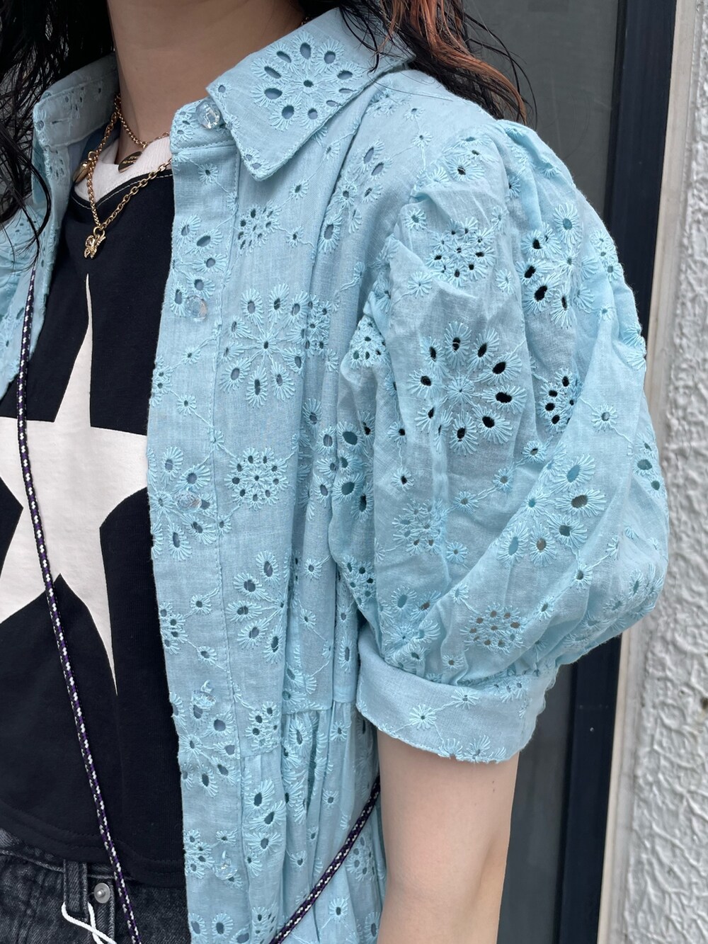 ブルー系のワンピース、ブラック系のショルダーバッグ、ブラック系のデニムパンツを着用したレディースの夏コーディネートの6枚目の写真