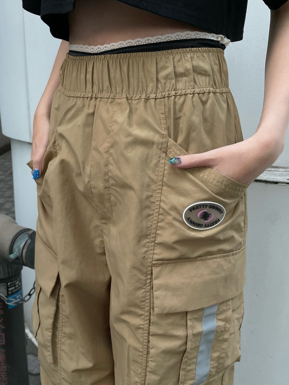ベージュ系のカーゴパンツ、ブラック系のTシャツ/カットソー、ブラック系のブーツを着用したレディースの夏コーディネートの7枚目の写真