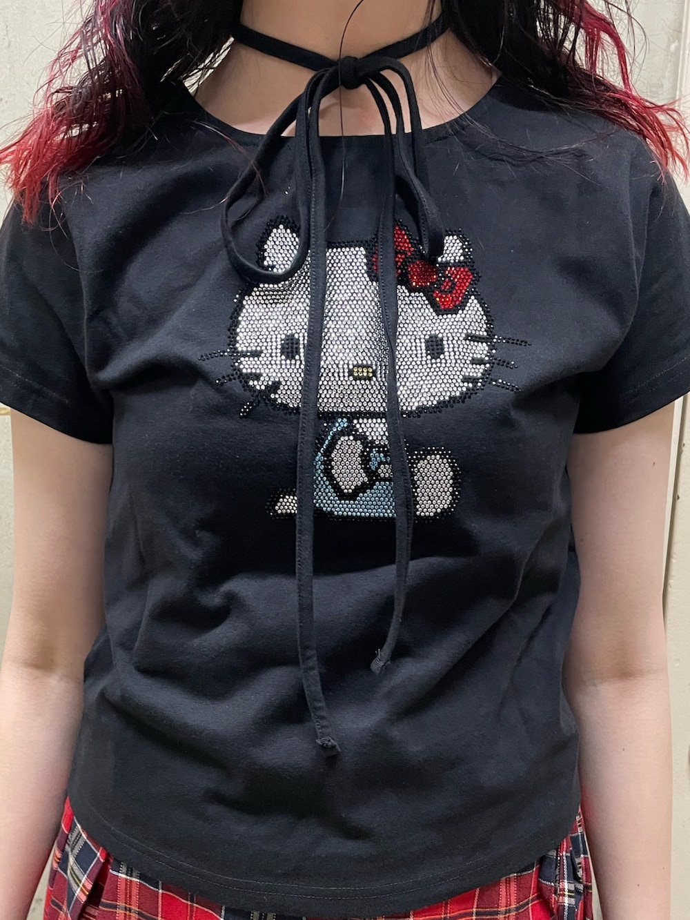 ブラック系のTシャツ/カットソー、レッド系のスカート、ブラック系のブーツを着用したレディースの春コーディネートの6枚目の写真