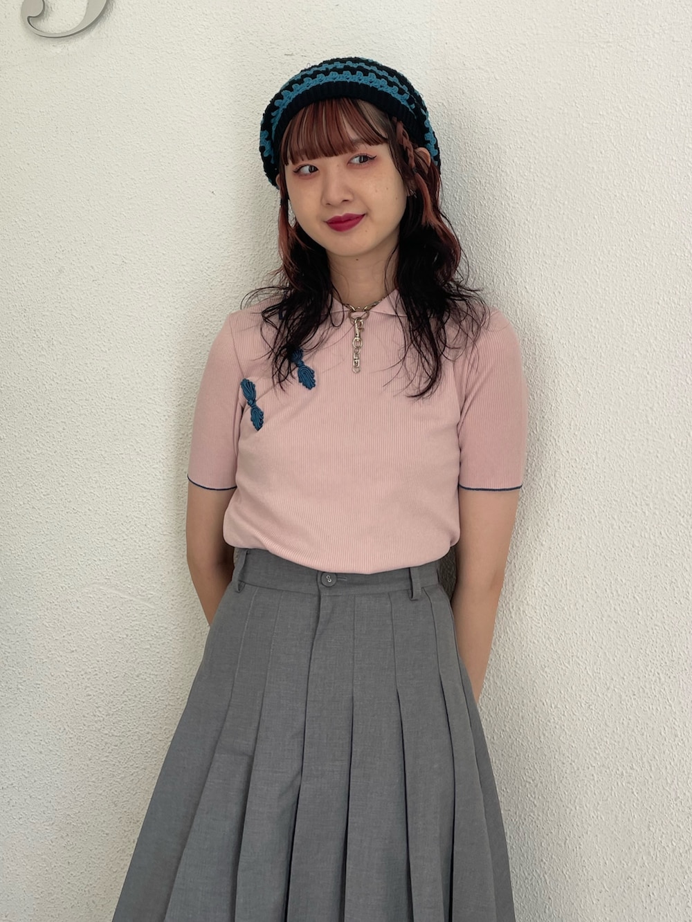 グレー系のスカート、ピンク系のポロシャツ、ブラック系のその他シューズを着用したレディースの春コーディネートの4枚目の写真