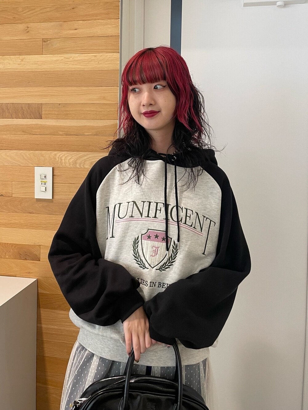 グレー系のパーカー、ホワイト系のワンピース、ブラック系のボストンバッグを着用したレディースの冬コーディネートの4枚目の写真