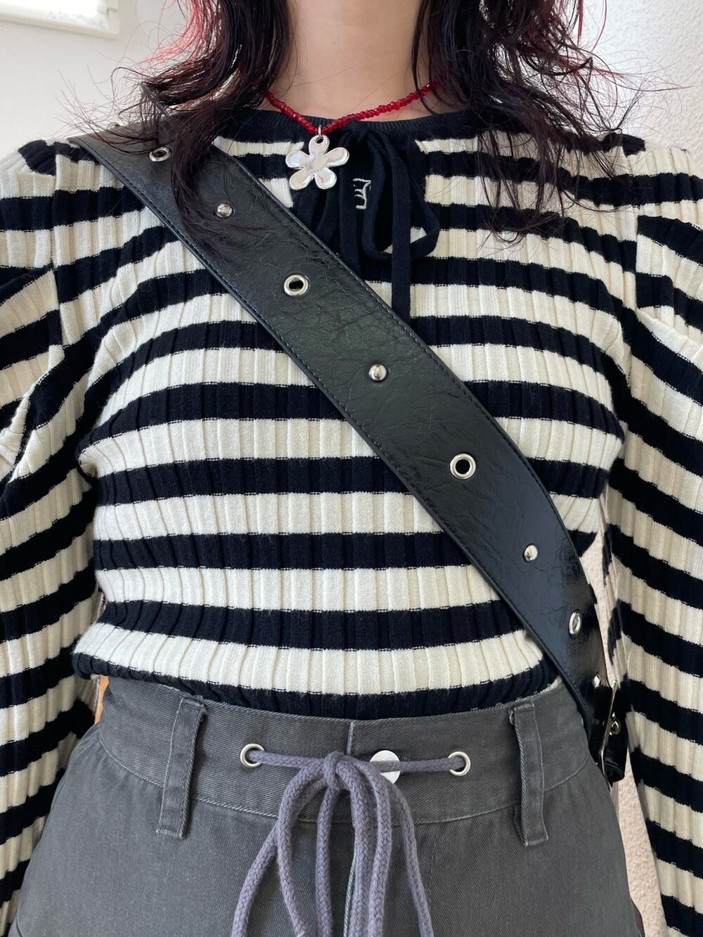 ホワイト系のニット/セーター、ブラック系のブーツ、ブラック系のスカートを着用したレディースの冬コーディネートの5枚目の写真