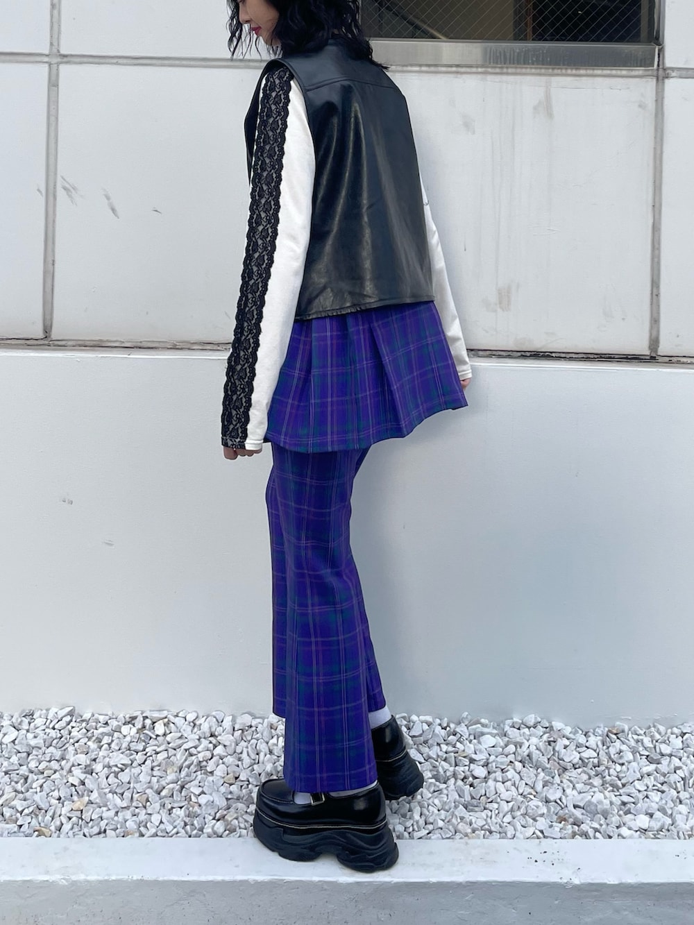 ブラック系のスニーカー、ブラック系のベスト、ホワイト系のTシャツ/カットソーを着用したレディースの冬コーディネートの3枚目の写真