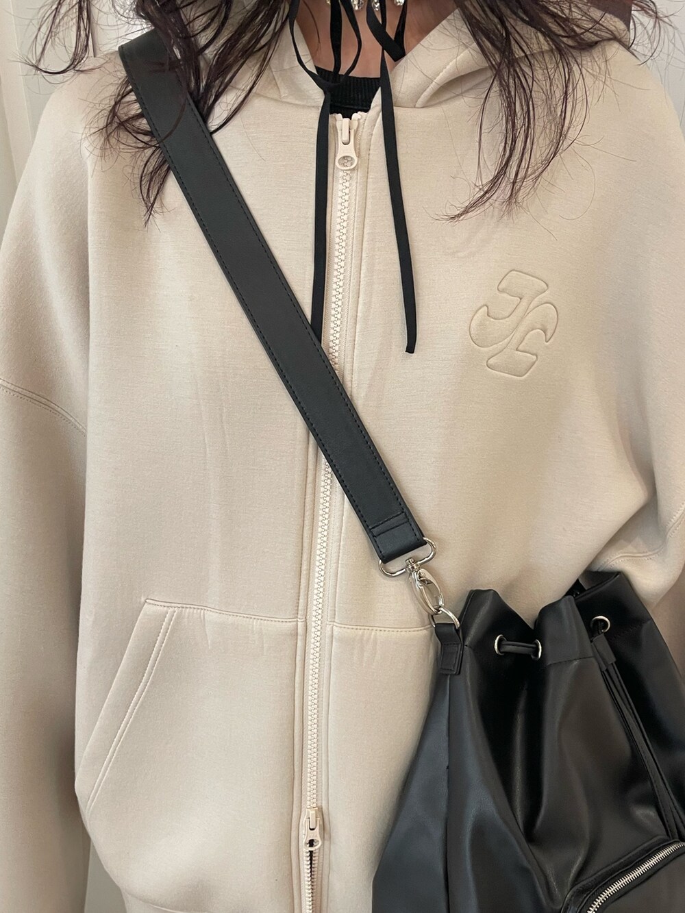 ホワイト系のパーカー、ブラック系のバックパック/リュック、ブラック系のスカートを着用したレディースの冬コーディネートの5枚目の写真