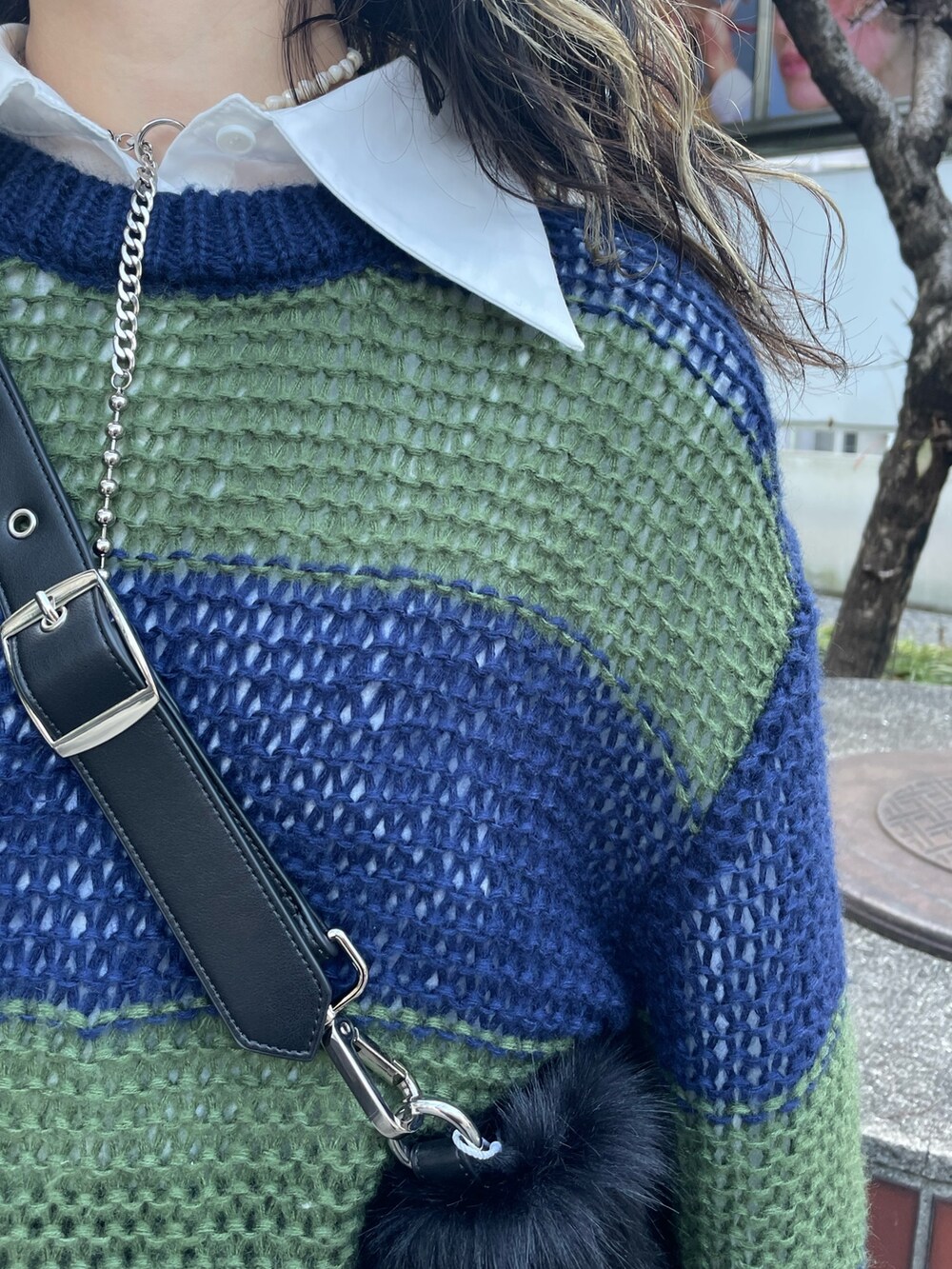 ブラック系のショルダーバッグ、ブラック系のブーツ、ブルー系のニット/セーターを着用したレディースの冬コーディネートの5枚目の写真