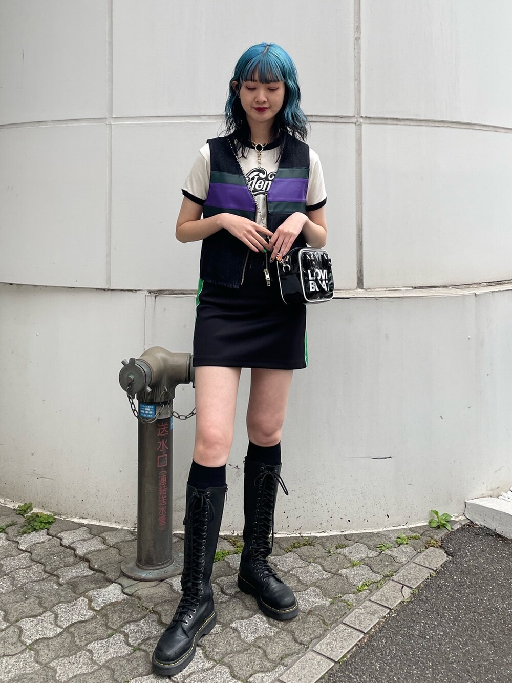 ブラック系のスカート、ブラック系のベスト、ブラック系のボストンバッグを着用したレディースの春コーディネートの2枚目の写真