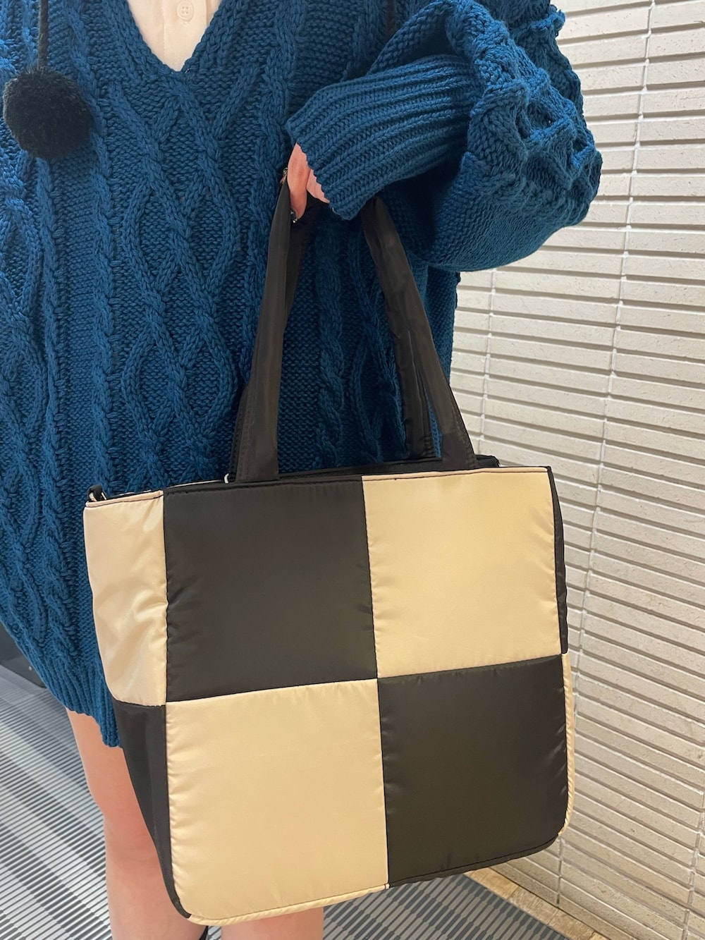 ブルー系のニット/セーター、ホワイト系のシャツ/ブラウス、ホワイト系のトートバッグを着用したレディースの冬コーディネートの8枚目の写真