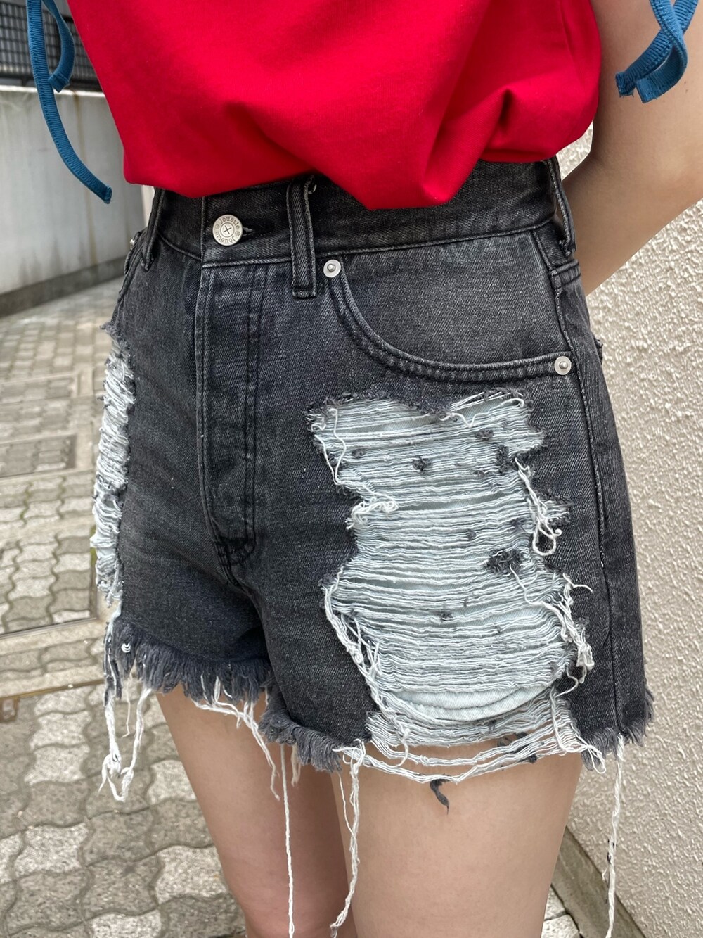ブラック系のデニムパンツ、シルバー系のハンドバッグ、レッド系のTシャツ/カットソーを着用したレディースの夏コーディネートの7枚目の写真