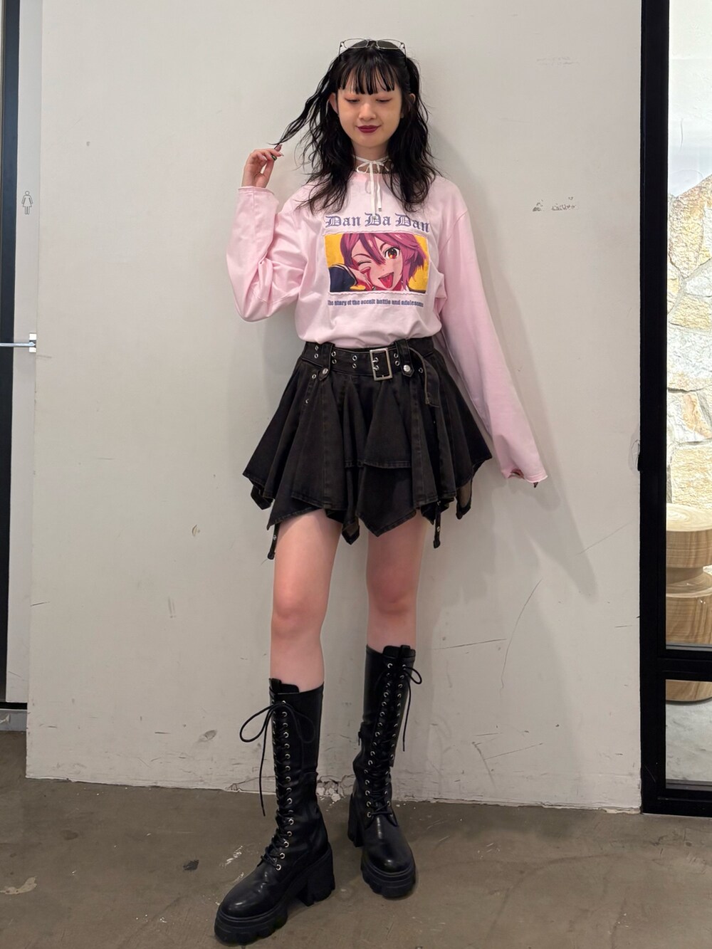 ピンク系のTシャツ/カットソー、ブラック系のデニムスカート、ブラック系のブーツを着用したレディースの夏コーディネートの2枚目の写真