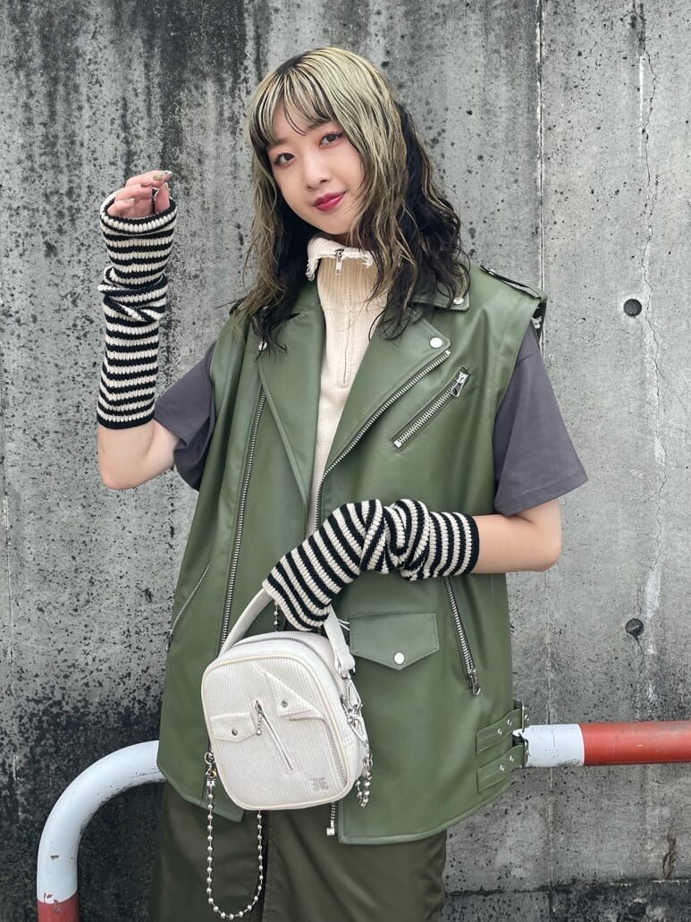 ブラック系のブーツ、ベージュ系のスカート、ホワイト系のベストを着用したレディースの秋コーディネートの4枚目の写真