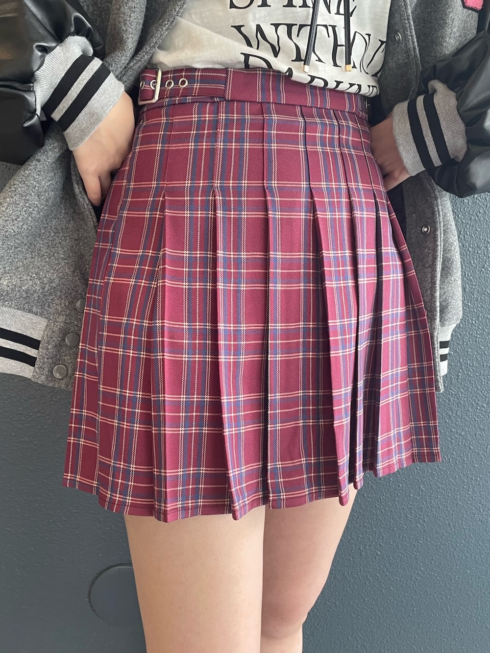 ピンク系のスカート、グレー系のスタジャン、ホワイト系のTシャツ/カットソーを着用したレディースの秋コーディネートの6枚目の写真