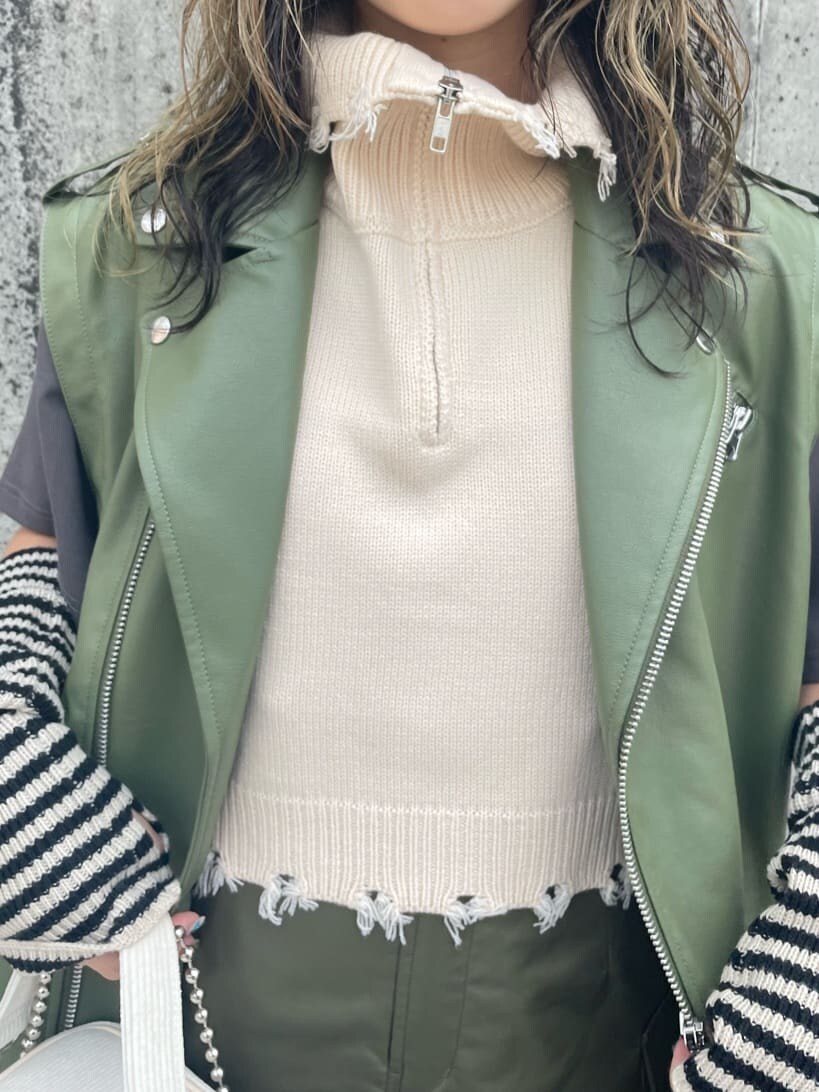 ブラック系のブーツ、ベージュ系のスカート、ホワイト系のベストを着用したレディースの秋コーディネートの5枚目の写真