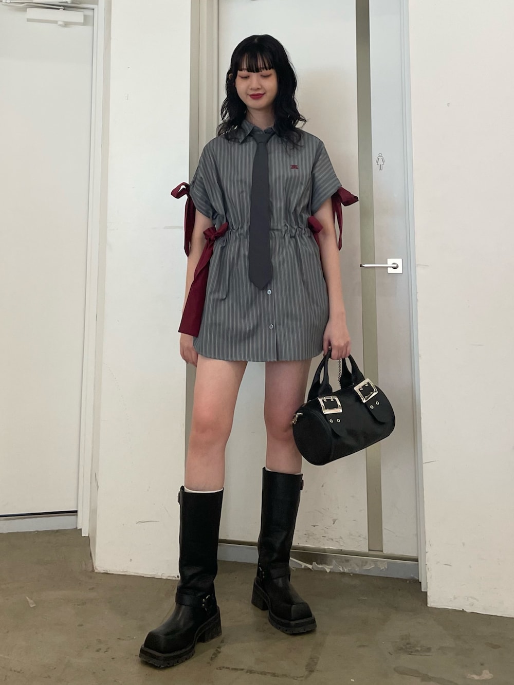 グレー系のシャツ/ブラウス、グレー系のネクタイ、ブラック系のボストンバッグを着用したレディースの夏コーディネートの2枚目の写真