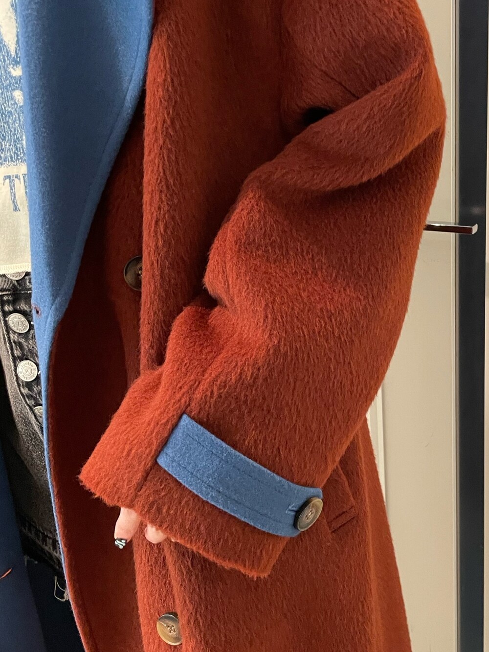 ブラウン系のチェスターコート、ホワイト系のTシャツ/カットソー、ブラック系のデニムパンツを着用したレディースの秋コーディネートの7枚目の写真