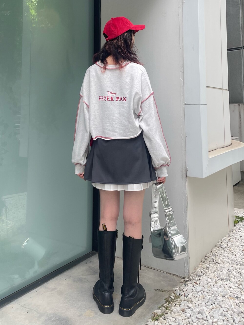 グレー系のスウェット、グレー系のスカート、シルバー系のハンドバッグを着用したレディースの夏コーディネートの4枚目の写真